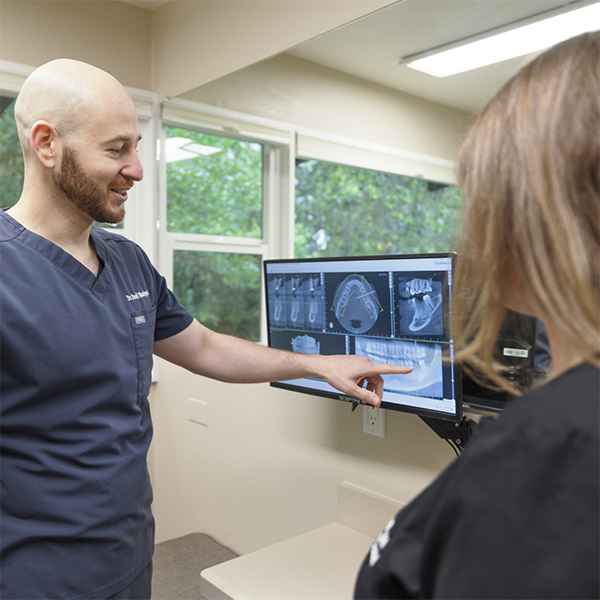 Doctor David showing a patient x-rays of their teeth