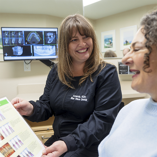 Dental team member showing a paper to a patient