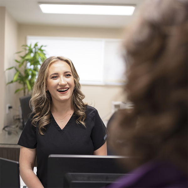 Dental team member greeting a patient at the front desk