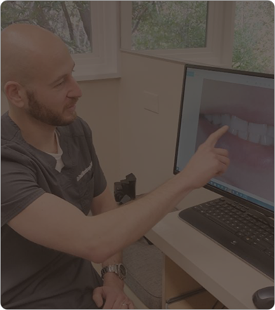 Dentist pointing to an image of teeth on a screen