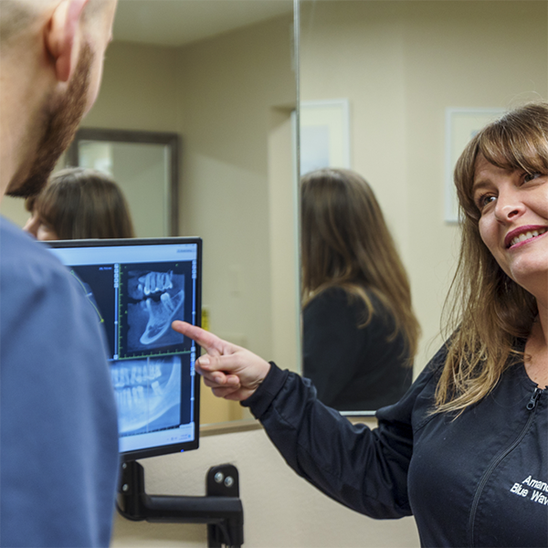 Dental team member showing a patient one of their x-rays
