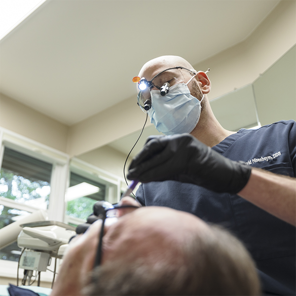 Doctor David examining a patient's gums