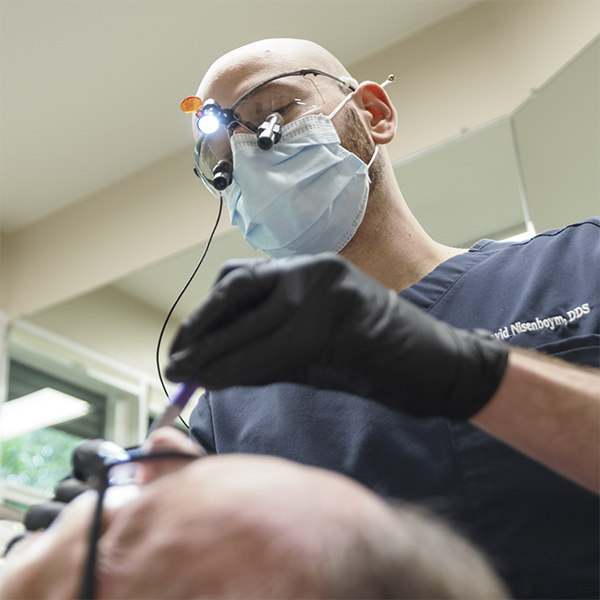 Doctor David wearing a face mask and eye gear while treating a patient