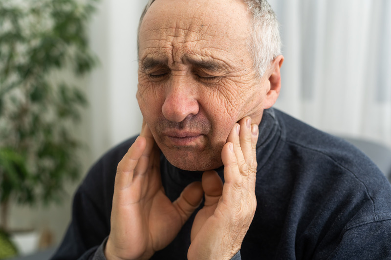 Older patient rubbing their jaw