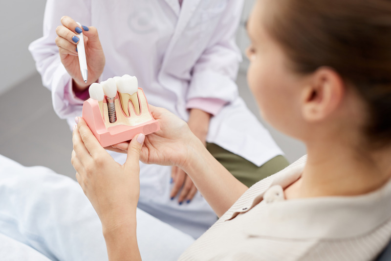 Patient looking at a model of a dental implant